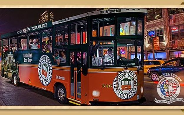 Nighttime charm: Old Town Nashville Hop-On, Hop-Off Trolley bus glides through the city, illuminated by enchanting lights.